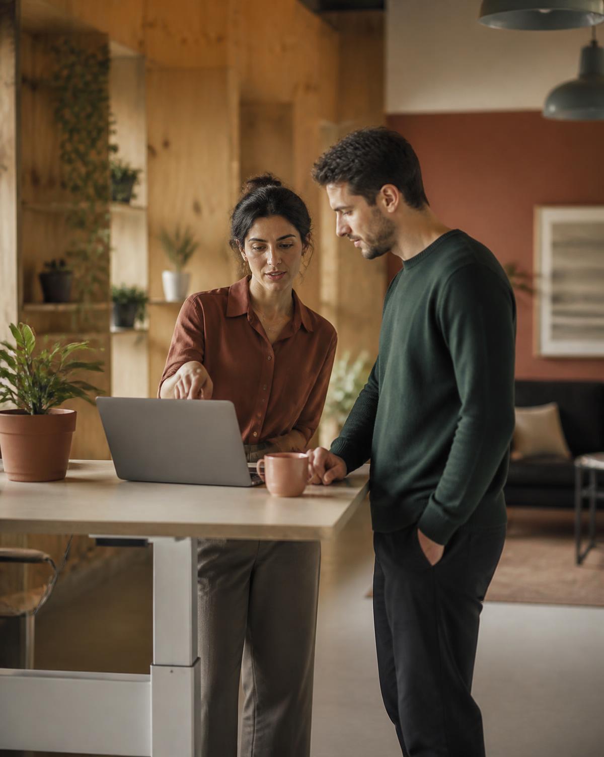 Two colleagues reviewing commercial data together at a standing desk.